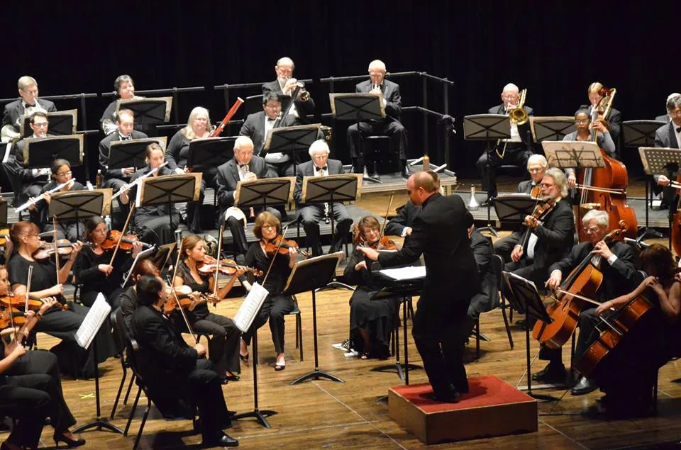 Симфонический оркестр Alhambra Orchestra выступает на сцене с дирижером.