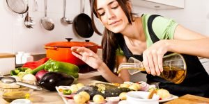 o-PREPARING-HEALTHY-FOOD-facebook-300x150 Woman pouring olive oil over fish