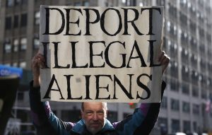 anti-immigrant-RTX21KNY491239870-e1501163564935-300x191 An anti-immigration activist holds signs near an immigration rally against raids on undocumented immigrants in New York