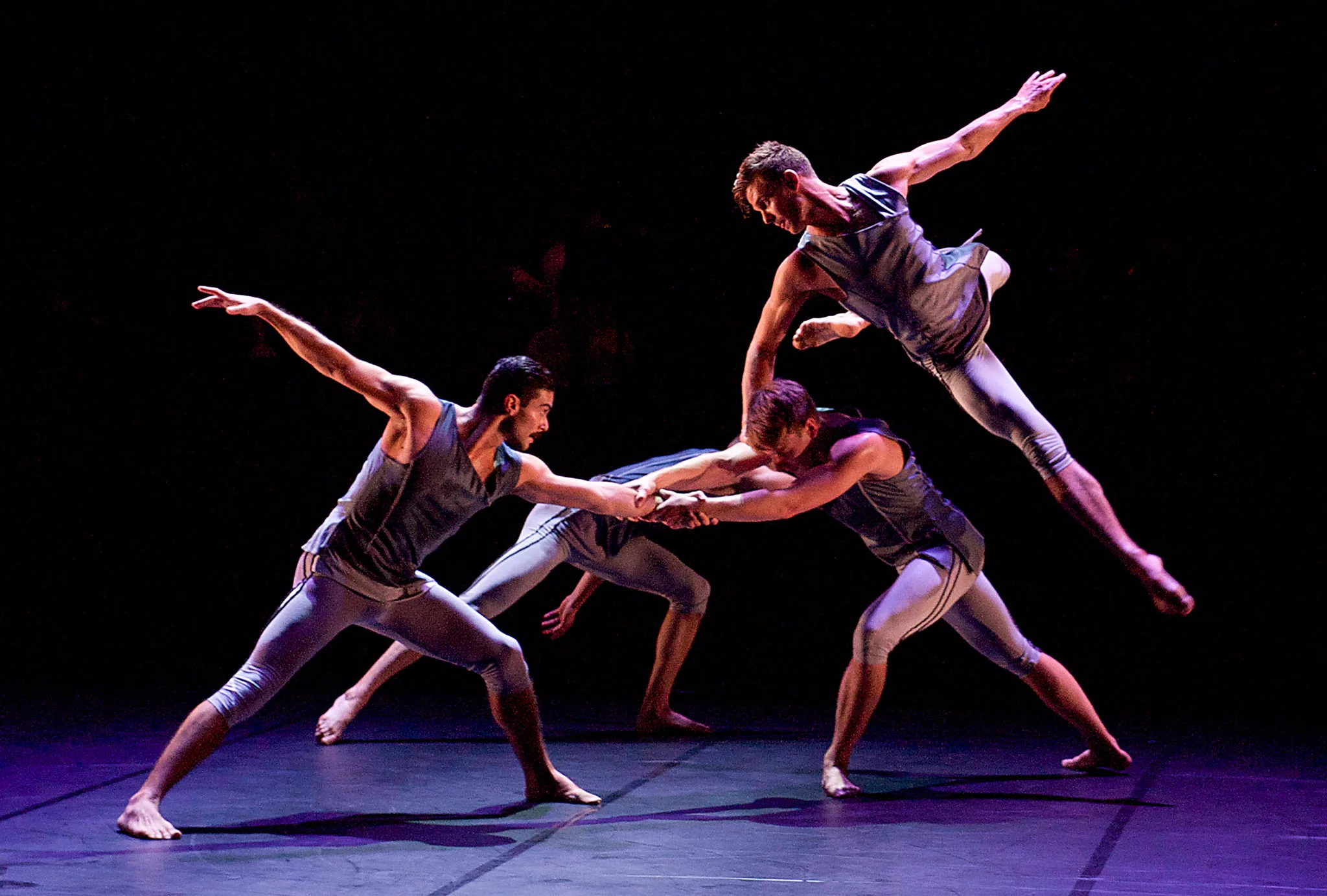 Четверо артистов труппы BalletBoyz исполняют танец на сцене.