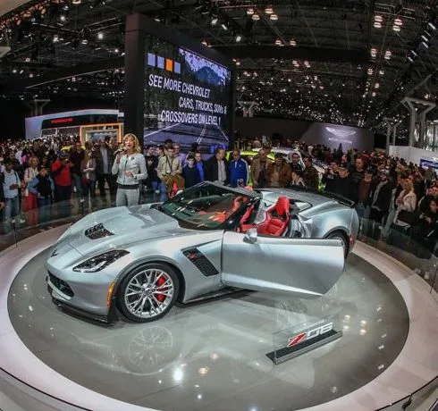 Серебристый спорткар Chevrolet Corvette на вращающейся платформе на автосалоне