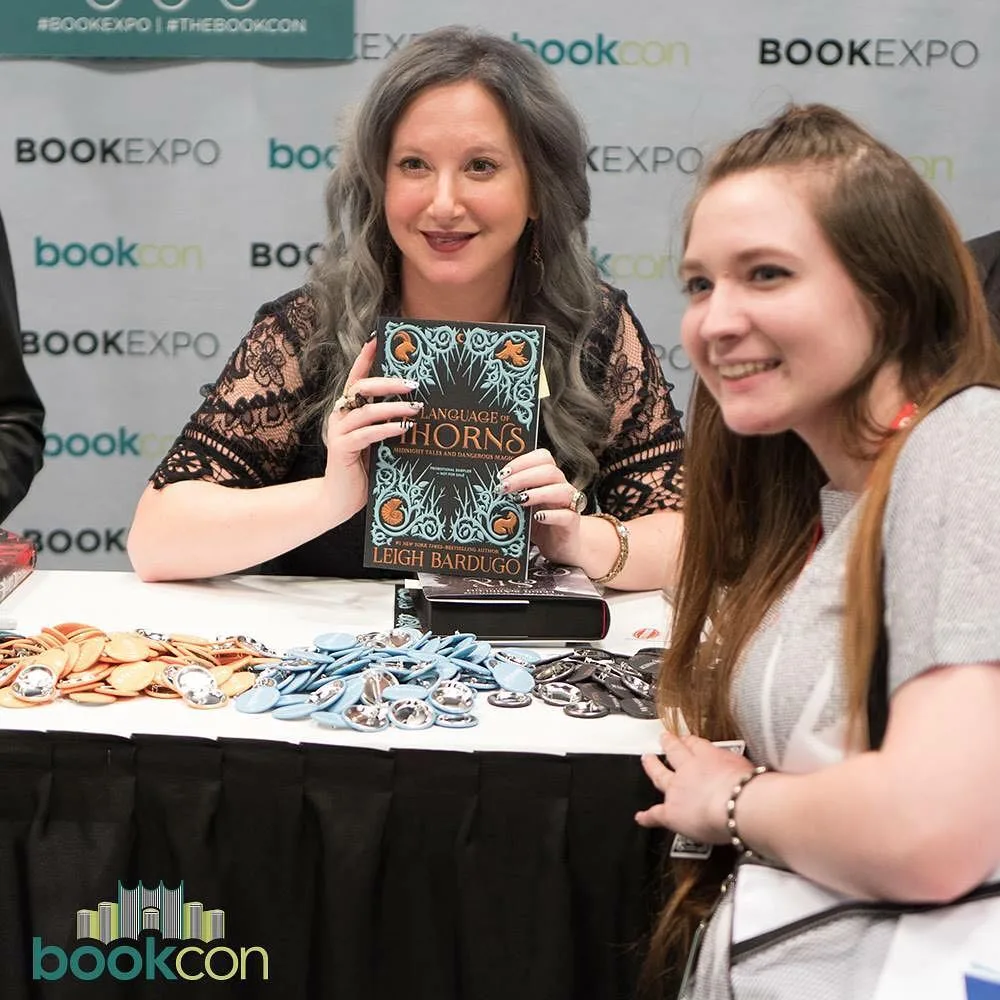 Писательница Ли Бардуго держит книгу «Язык шипов» на фестивале BookCon.