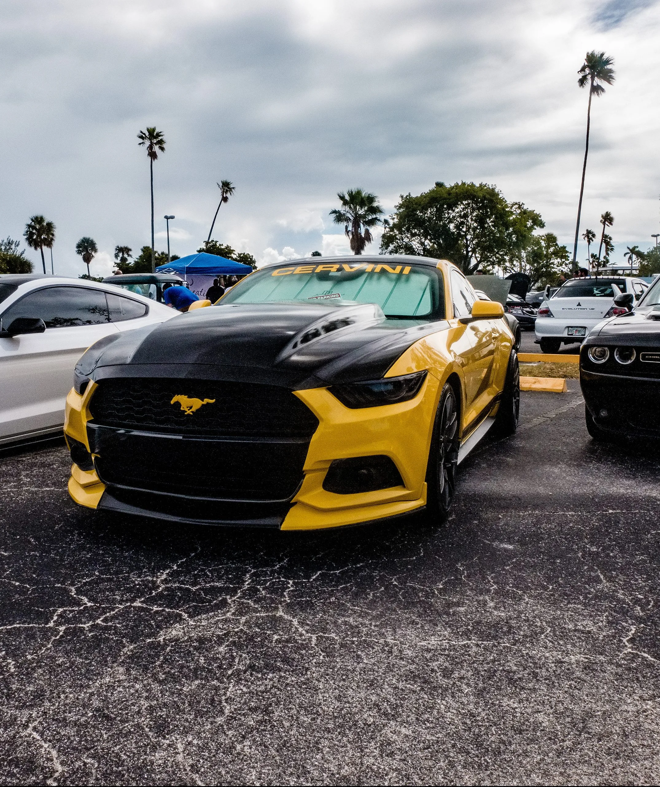 Желто-черный спорткар Ford Mustang на парковке автолюбителей.