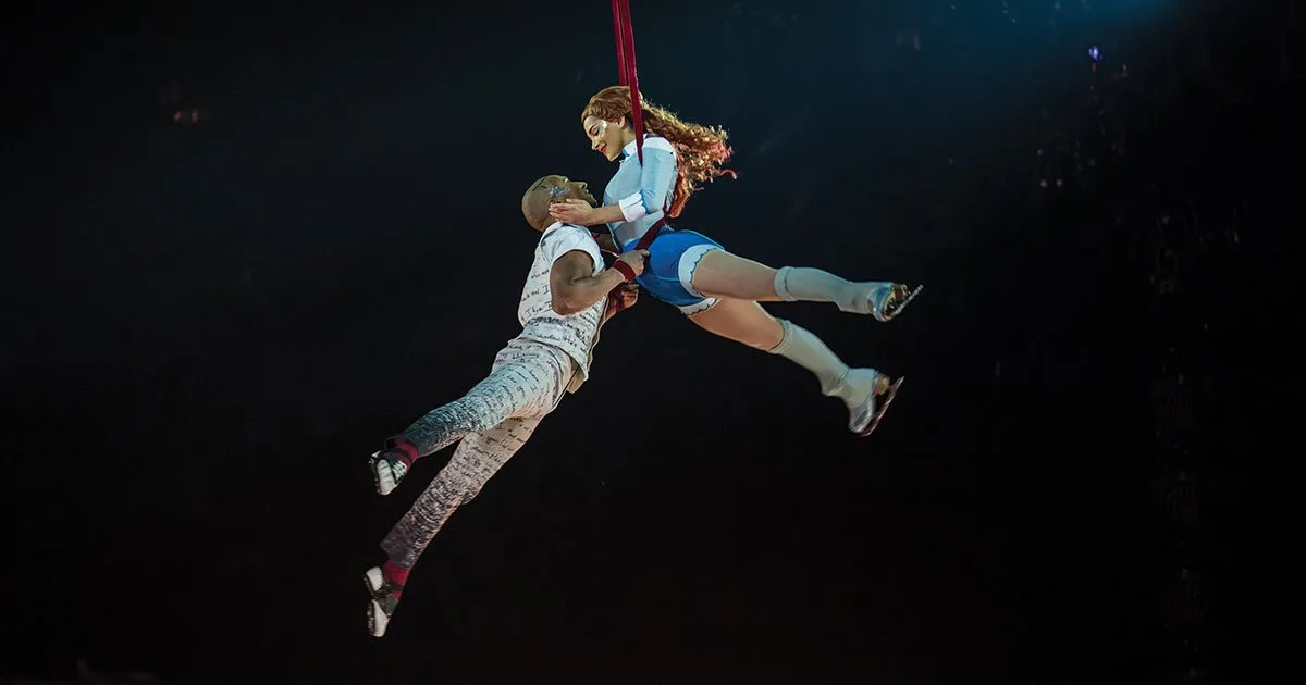Воздушные гимнасты выступают под куполом на шоу Cirque du Soleil.