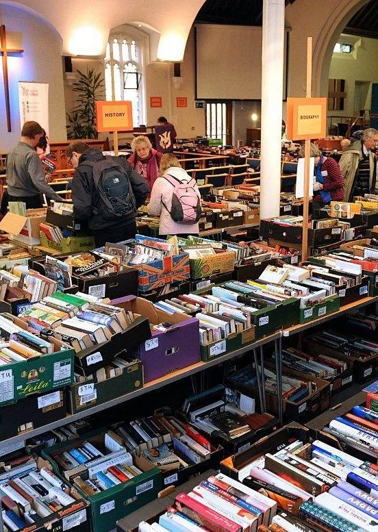 Люди выбирают книги на столах во время книжной ярмарки