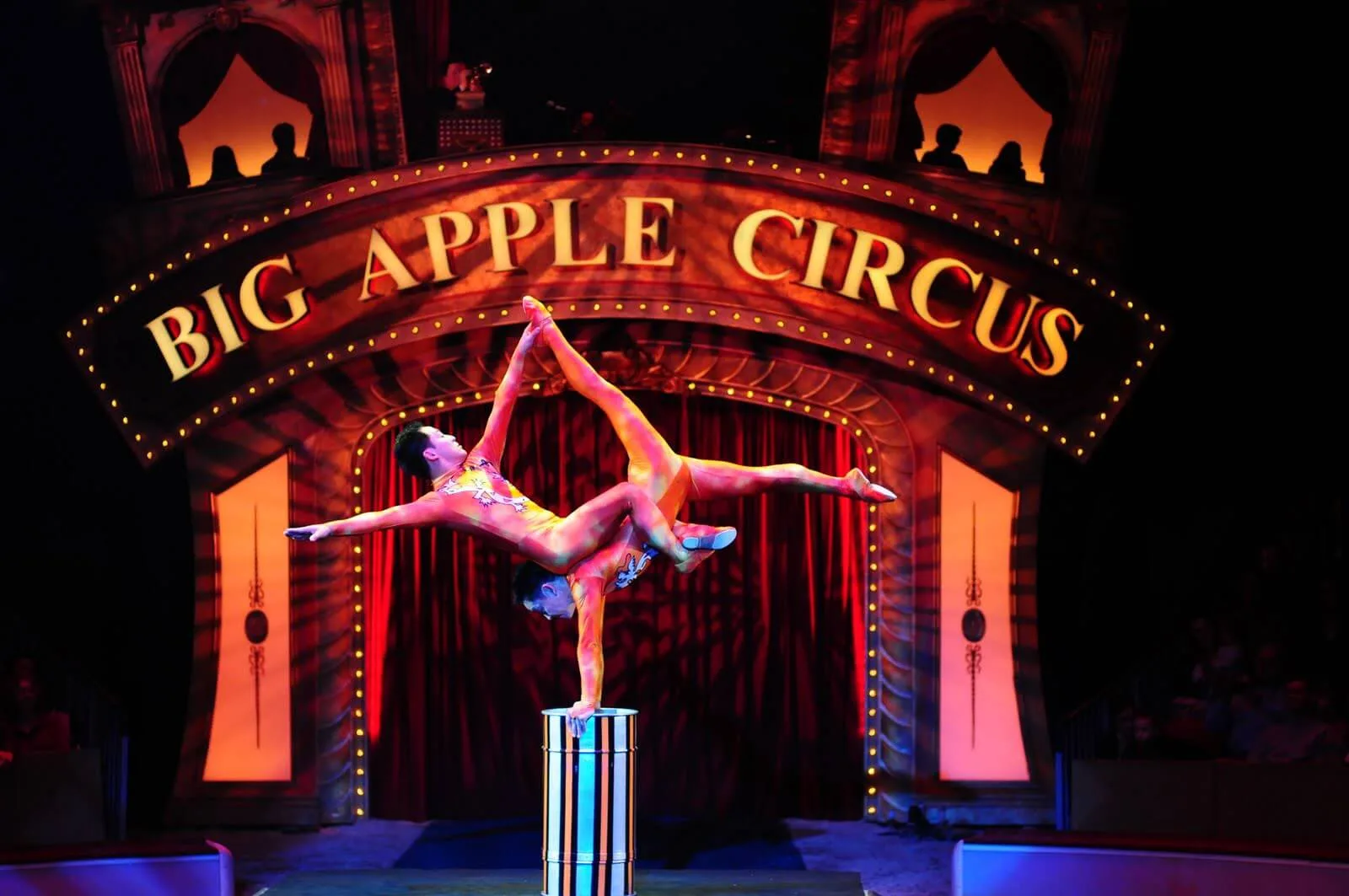 Акробаты выступают под вывеской Big Apple Circus.