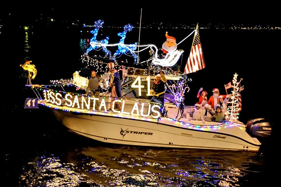 Светящийся катер с надписью USS Santa Claus во время ночного парада.