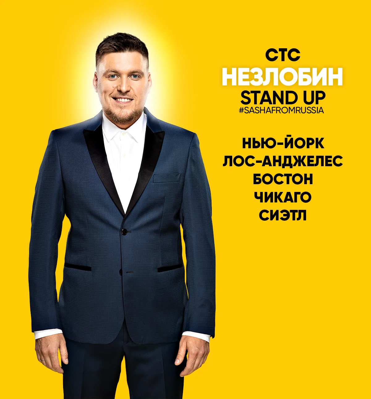 Александр Незлобин в синем костюме на желтом фоне афиши.