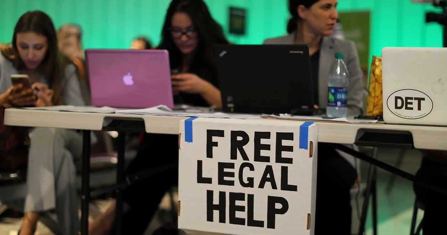 Табличка с надписью Free Legal Help на столе с ноутбуками.