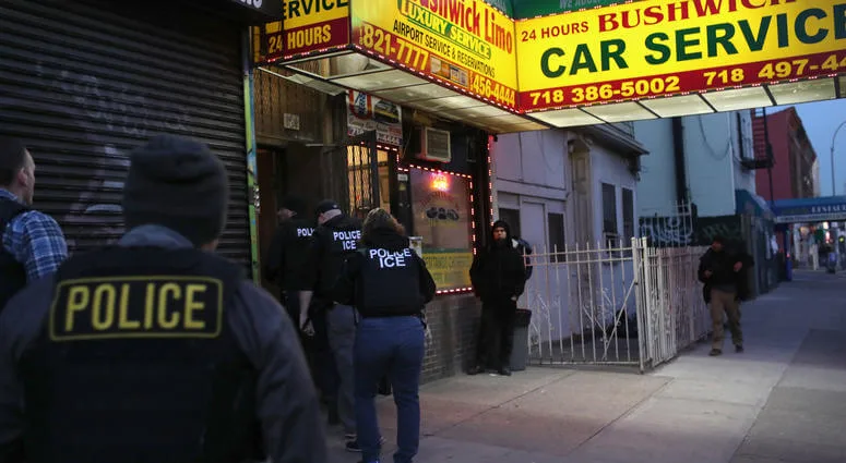 Сотрудники иммиграционной полиции США возле здания с вывеской Bushwick Car Service.