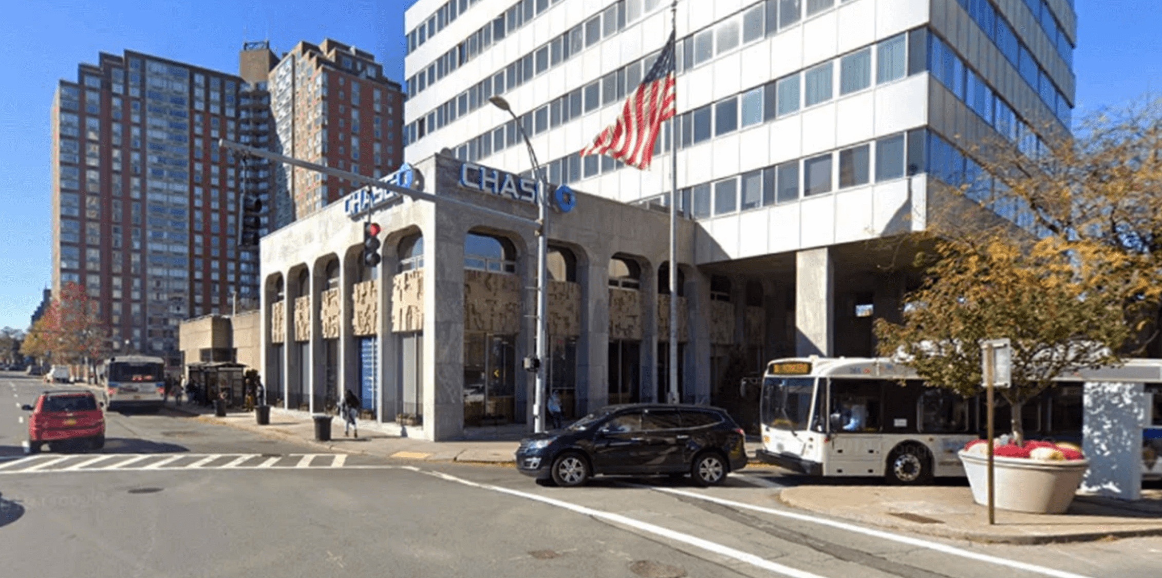 Здание банка Chase на перекрестке с проезжающим автобусом.