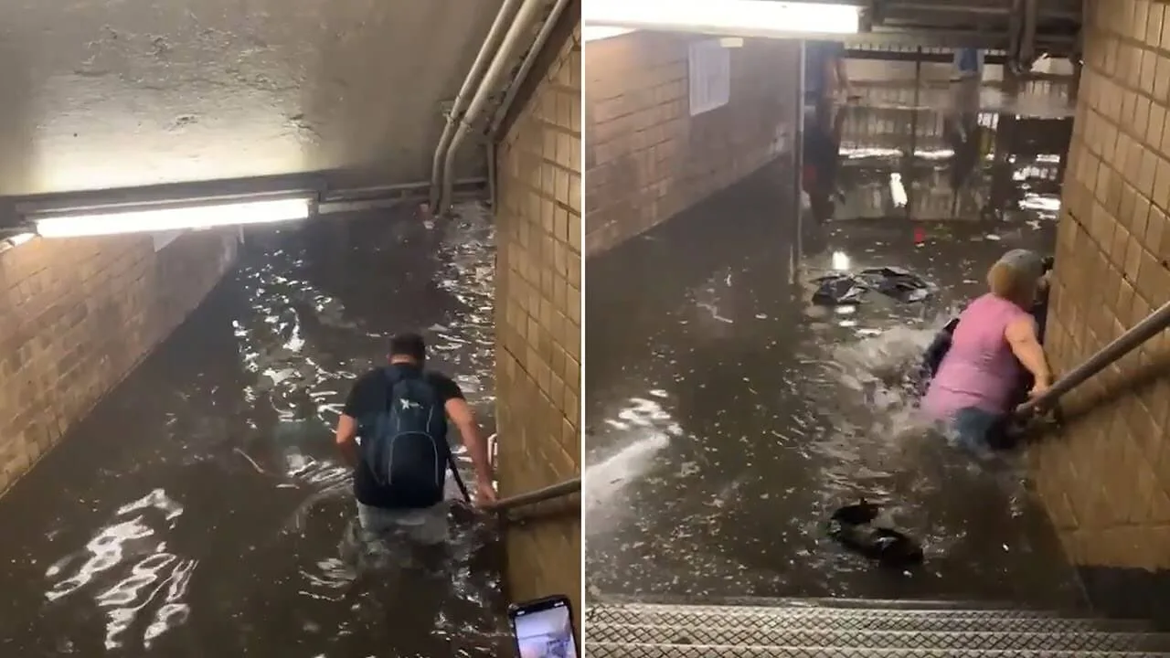 Люди идут по колено в воде по затопленному переходу метрополитена.